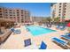 Sparkling blue community pool surrounded by lounge chairs and lush landscaping at 7970 E Camelback Rd # 604, Scottsdale, AZ 85251