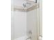 Close up of a shower featuring white subway tile, a mosaic accent and a chrome shower head and handle at 7970 E Camelback Rd # 604, Scottsdale, AZ 85251