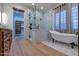 Bathroom featuring a glass enclosed shower, free-standing tub, and hardwood floors at 8214 N 16Th St, Phoenix, AZ 85020