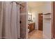 Elegant bathroom featuring a granite-topped vanity, tiled shower, and decorative shower curtain for a luxurious feel at 8214 N 16Th St, Phoenix, AZ 85020