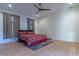 Minimalist bedroom with hardwood floors, ceiling fan, and red floral bedding at 8214 N 16Th St, Phoenix, AZ 85020