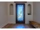 Elegant entryway with decorative glass door, recessed shelving, and a stylish bench at 8214 N 16Th St, Phoenix, AZ 85020