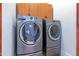 Modern laundry room with front-load washer and dryer, plus overhead cabinets at 8214 N 16Th St, Phoenix, AZ 85020