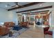 Bright open-concept space features exposed beams, hardwood flooring, and comfortable seating areas with a view of the kitchen at 8214 N 16Th St, Phoenix, AZ 85020