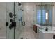 Close up of a glass enclosed shower with white marble and black fixtures at 8214 N 16Th St, Phoenix, AZ 85020