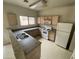 Standard kitchen featuring wood cabinets, white appliances, and a double sink at 9456 W Jamestown Rd, Phoenix, AZ 85037