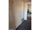 View of a hallway with a door and a glimpse into another room with storage bins at 1128 E Malibu E Dr, Tempe, AZ 85282