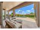 Covered outdoor patio with cozy seating area overlooking the pool and backyard at 11324 E Diamond Cholla Dr, Scottsdale, AZ 85255