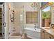 Bright bathroom with a soaking tub, spacious shower, and stylish chandelier at 11324 E Diamond Cholla Dr, Scottsdale, AZ 85255