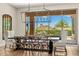 Elegant dining room with a modern chandelier and sliding glass doors showcasing backyard views at 11324 E Diamond Cholla Dr, Scottsdale, AZ 85255