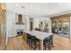 Well-lit kitchen featuring a large island with seating, custom cabinets, and direct access to the outdoor space at 11324 E Diamond Cholla Dr, Scottsdale, AZ 85255