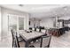 Dining area open to the living room and kitchen boasting sleek marble floors and a sliding door at 11957 W Daley Ln, Sun City, AZ 85373
