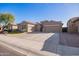 Charming single-story home featuring a three-car garage, desert landscaping and a spacious driveway at 11957 W Daley Ln, Sun City, AZ 85373