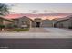 Charming single-story home featuring a three-car garage and low maintenance desert landscaping at sunset at 11957 W Daley Ln, Sun City, AZ 85373