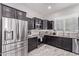 Modern kitchen featuring dark cabinetry, granite countertops, and stainless steel appliances at 11957 W Daley Ln, Sun City, AZ 85373