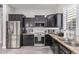 Modern kitchen featuring stainless steel appliances, granite countertops, and dark cabinetry at 11957 W Daley Ln, Sun City, AZ 85373