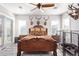 Cozy primary bedroom with ornate wooden bed frame, decorative pillows and a ceiling fan at 11957 W Daley Ln, Sun City, AZ 85373