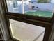 Window view of backyard with green lawn, partial patio, and outdoor grill area at 12230 N 47Th Dr, Glendale, AZ 85304