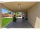 A covered backyard patio features plenty of room and overlooks the grass and backyard at 12425 W Willow Ave Ave, El Mirage, AZ 85335