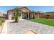 The landscaped backyard includes artificial grass, a patio, and desert flora at 12425 W Willow Ave Ave, El Mirage, AZ 85335
