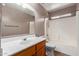 Bathroom with white countertops, a vanity with wood cabinets, and a shower-tub combination at 12425 W Willow Ave Ave, El Mirage, AZ 85335