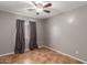 This bedroom features neutral paint, tile floor, a ceiling fan and a window with curtains at 12425 W Willow Ave Ave, El Mirage, AZ 85335