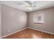 Neutral bedroom featuring hardwood floors, a ceiling fan and a window with bright, natural light at 12425 W Willow Ave Ave, El Mirage, AZ 85335