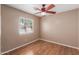 Relaxing bedroom featuring hardwood floors, a ceiling fan and a window with bright, natural light at 12425 W Willow Ave Ave, El Mirage, AZ 85335