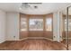 Bedroom with three windows and mirrored closet providing ample natural light and storage space at 12425 W Willow Ave Ave, El Mirage, AZ 85335