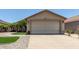Charming single-story home featuring a beige exterior, a two car garage, and meticulous landscaping at 12425 W Willow Ave Ave, El Mirage, AZ 85335