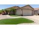 Charming single-story home featuring a beige exterior, a two car garage, and meticulous landscaping at 12425 W Willow Ave Ave, El Mirage, AZ 85335