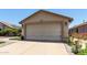 Charming single-story home featuring a beige exterior, a two car garage, and meticulous landscaping at 12425 W Willow Ave Ave, El Mirage, AZ 85335