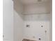 A clean laundry room features shelving and hook ups for a washer and dryer at 12425 W Willow Ave Ave, El Mirage, AZ 85335