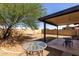 The backyard features a covered patio with a hammock, table and chairs and a tree, perfect for relaxation and outdoor entertainment at 13041 N 51St Dr, Glendale, AZ 85304