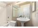 Cozy bathroom featuring a pedestal sink, tub, and tiled walls, blending comfort and functionality at 13041 N 51St Dr, Glendale, AZ 85304