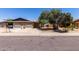 Single-story home with brick accents, a two-car garage, mature tree, and landscaping at 13041 N 51St Dr, Glendale, AZ 85304