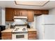 Kitchen with wood cabinets and white appliances under recessed lighting at 13041 N 51St Dr, Glendale, AZ 85304