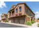 A three-story townhome boasts a stucco exterior, multi-car garages, and eye-catching stone accents at 1350 S Greenfield Rd # 1005, Mesa, AZ 85206