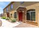Charming home entrance showcases a red door, stone accents, and manicured landscaping at 1350 S Greenfield Rd # 1005, Mesa, AZ 85206