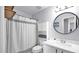Well-lit bathroom features a vanity, toilet, and shower with a decorative mirror and shelving at 14952 W Maui Ln, Surprise, AZ 85379