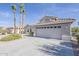 Lovely single-story home with a tiled roof, complemented by a concrete driveway and palm trees at 15411 W Amelia Dr, Goodyear, AZ 85395