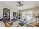 Comfortable living room featuring a large TV, neutral decor, and sliding glass doors to the patio at 15411 W Amelia Dr, Goodyear, AZ 85395