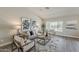 Well-decorated living room with stylish furniture, modern art, and a large window overlooking the backyard at 15411 W Amelia Dr, Goodyear, AZ 85395