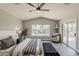 Beautifully decorated main bedroom showcasing a ceiling fan, slider to the back yard, and an inviting sitting area at 15411 W Amelia Dr, Goodyear, AZ 85395