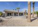 Desert home featuring a spacious outdoor patio and beautifully landscaped backyard with palm trees at 15411 W Amelia Dr, Goodyear, AZ 85395