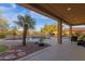 Covered patio with a view of the backyard including a pool, spa, outdoor kitchen, and mature palms at 16401 S 29Th Ave, Phoenix, AZ 85045