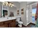Well-lit bathroom with a walk-in shower, wood vanity, and access to the bedroom at 16401 S 29Th Ave, Phoenix, AZ 85045