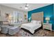 Stylishly decorated bedroom with large upholstered headboard, plantation shutters, and colorful accents at 16401 S 29Th Ave, Phoenix, AZ 85045