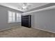 Bedroom featuring carpet flooring, light gray walls, and bright light filtering window shutters at 16401 S 29Th Ave, Phoenix, AZ 85045