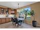 Cozy dining area featuring wood cabinets, tile floors, and a bright window overlooking the backyard at 16401 S 29Th Ave, Phoenix, AZ 85045